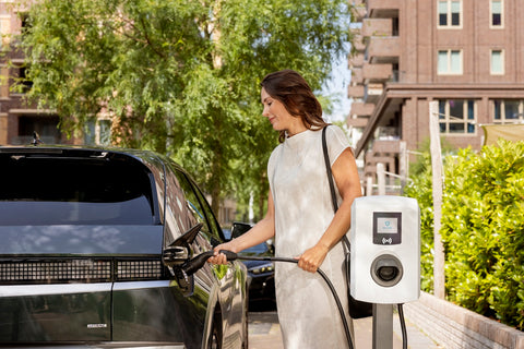 Vrouwelijk model wil haar auto opladen met de Alfen Eve Single Pro-line wit