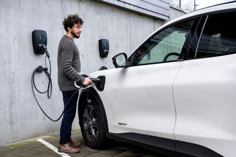 Zaptec Pro met mannelijk model en witte auto 